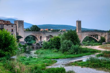 İspanya 'nın Katalonya şehrinde Fluvia Nehri' nin aktığı Besal kasabasının amblematik ortaçağ köprüsü..