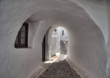 Binibeca 'nın beyaz duvarlarından geçerek. Balear Adaları, Menorca 'da güzel bir balıkçı köyü.