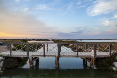 Ebro Delta Doğal Parkı 'ndaki Tancada Gölü ufukta güneş batarken köprüden görüldü..