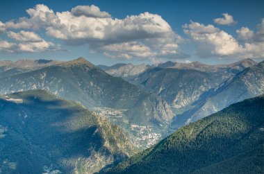 Andorra dağlarının zirveleri güneş ışınları ve bulutlar yüzünden güneş ve gölge arasında..
