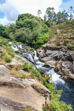 Caldeiras do Rio Castro olarak bilinen bölgede su hızlı akar ve kaya oluşumları arasında şelaleler oluşur. Galiçya, İspanya.