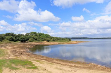 Güneşli bir günde, mavi gökyüzünde bulutlar olan Fervenza rezervuarı. Galiçya, İspanya.