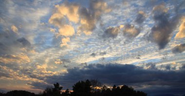 Mavi gökyüzü romantik bir dokunuşla boyanmış ve ufukta belli bir drama var..