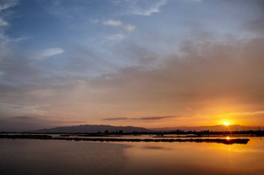 Ebro Deltası 'nın dağlarında, sakin bir denizin sularını aydınlatan bir ateş ufku..