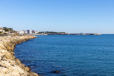 Seascape view of the coast and the town of l'Ampolla on the horizon, on a clear day. Tarragona, Catalonia, Spain. clipart