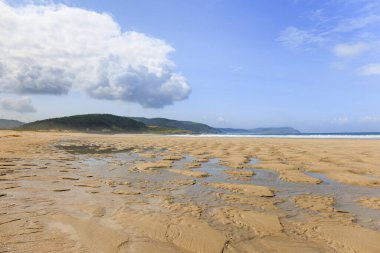 Ufukta dağlar, Muxa, Galiçya ve İspanya 'nın bulutları, yüksek gelgitte kumların arasındaki su..