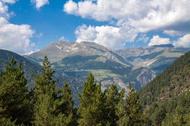 Andorra dağlarının tepesindeki bulutlar ormandan görünüyor.