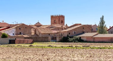 Pozondon: Aragon, Teruel, İspanya 'da ekin tarlalarıyla çevrili kırmızımsı evlerden oluşan küçük bir köy