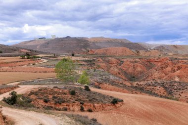 Kızıl toprak çöl manzarasında bulutlarla kaplı bir gökyüzü