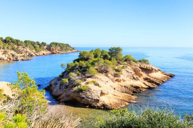 Quiet cove on the Costa Dorada, with a small rocky islet. Tarragona, Spain.