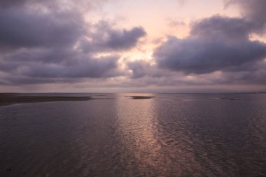 Gökyüzünü ve denizi süsleyen sihirli pembe renklerin günbatımı Ebro Delta 'da