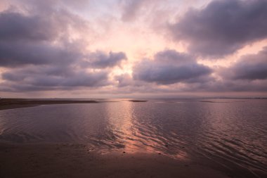 Gün batımında denize yansıyan pembe bulutlar Ebro Delta, Katalonya, İspanya