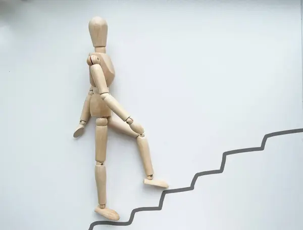 A wooden puppet climbs up the stairs. High quality photo