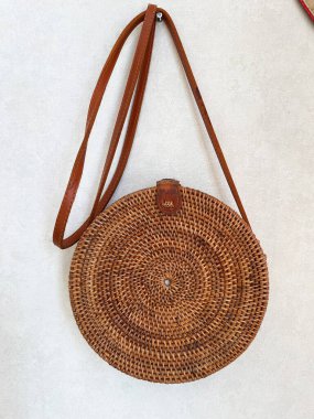 Beyaz arka planda kayışı olan yuvarlak bir çanta. Yüksek kalite fotoğraf