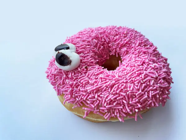 Mavi arka planda gözleri olan pembe bir çörek. Yüksek kalite fotoğraf
