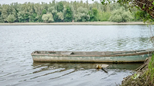木船拴在岸上 秋天停泊在湖岸上的小木渔船的照片 — 图库照片