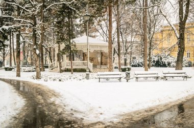 Şehir parkı karla kaplı. Şehir parkındaki ahşap banklar kış battaniyesiyle örtülü. Ocak ayında şehir parkı kış battaniyesiyle örtüldü..