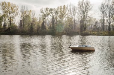 Tahta tekne gölün kıyısına demirlemiş..
