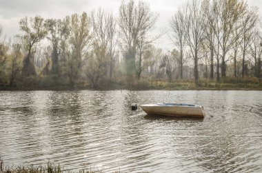 Tahta tekne gölün kıyısına demirlemiş..