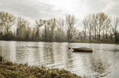 Tahta tekne gölün kıyısına demirlemiş..