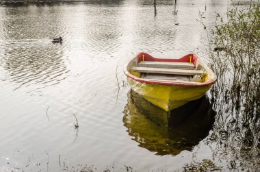Tahta tekne gölün kıyısına demirlemiş..