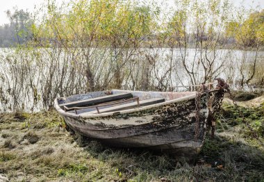 Tahta tekne gölün kıyısına demirlemiş..
