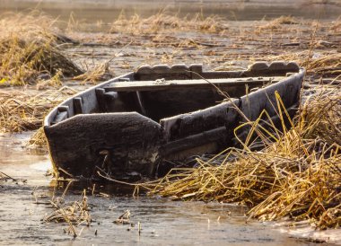 Sırbistan 'ın Novi Sad kenti yakınlarındaki Tuna Nehri' nin kolunda unutulmuş bir balıkçı teknesi.