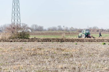 Tarlaları ve traktörü olan kışın panoramik manzarası.