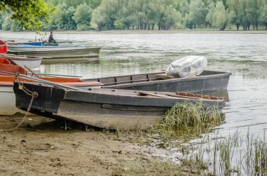 Kıyıya bağlı ahşap balıkçı tekneleri. Sonbaharda gölün kıyısına demirlemiş küçük ahşap balıkçı tekneleri manzarası..