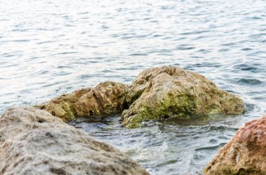 Yunanistan 'ın Pefkochori kentindeki küçük turist kasabasında öğleden sonra plajda taşlar.