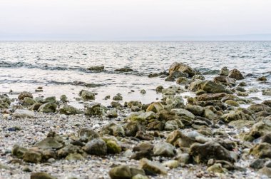 Yunanistan 'ın Pefkochori kentindeki küçük turist kasabasında öğleden sonra plajda taşlar.