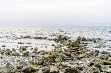 Yunanistan 'ın Pefkochori kentindeki küçük turist kasabasında öğleden sonra plajda taşlar.