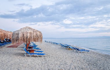 Sabahları küçük Pefkochori kasabasında güneşli ve güneşli plaj manzarası..