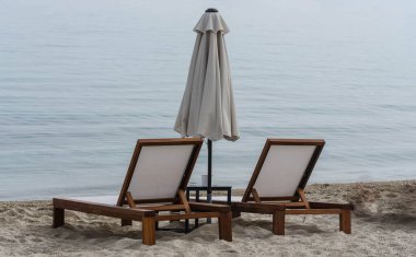 View of the beach with parasols and suView of the beach with parasols and sun loungers in the small town of Pefkochori.n loungers in the small town of Pefkochori, in the morning.
