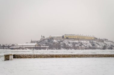 Novi Sad, Sırbistan - 23 Ocak 2014: Petrovaradin Kalesi kışın Sis yoluyla Tuna Nehri kıyılarından.