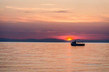 Fishing boat on the high seas, in the early morning hours in Leptokarya,Greece. clipart