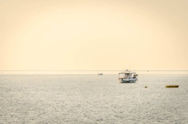 Fishing boat on the high seas, in the early morning hours in Leptokarya,Greece. clipart