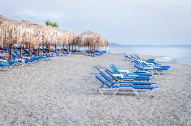 Sabahları küçük Pefkochori kasabasında güneşli ve güneşli plaj manzarası..