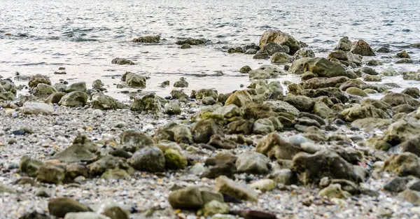 Stones on the beach in the small tourist town of Pefkochori, Greece in the late afternoon.