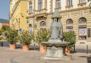 Pecs, Hungary - October 06, 2018: Cityscape on main city Square of Pecs - Hungary. Zsolnay fountain landmark Pecs. Zsolnay manufactured sculptures on a fountain in the main square in Pecs Hungary