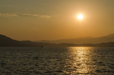 Evia Adası, Yunanistan - 01 Temmuz. 2020: Yunanistan 'ın Evia adasında günbatımı. Yunanistan 'ın Ege Denizi' ndeki Evia adasında günbatımının panoramik görüntüsü. Evia Yunanistan adasındaki sakin Ege Denizi 'nde güzel bir gün batımı