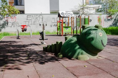 Novi Sad, Sırbistan. Nisan - 26. 2022 yılı. Güneşli bir bahar günü erken saatlerde oynanacak slayt ve oyunlar da dahil olmak üzere çeşitli oyuncakları olan renkli oyun alanı ekipmanları..