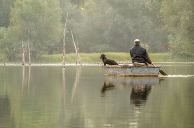 Sports fisherman in a wooden boat in the National Park - Sodros. Fishermen paddling moves to the other side of the coast in their wooden boats.