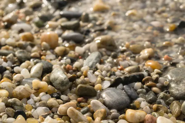 Pebbles on the beach in the small tourist town of Pefkochori, Greece in the late afternoon.