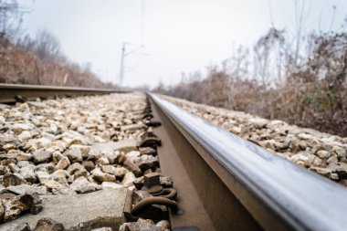 Scenic view of straight railway or railroad track receding into distance on foggy day. The concept of traveling by train. clipart