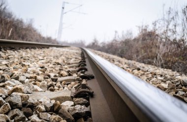 Scenic view of straight railway or railroad track receding into distance on foggy day. The concept of traveling by train. clipart