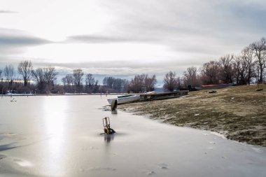 Tahta tekneler gölün donmuş sularında unutuldu..