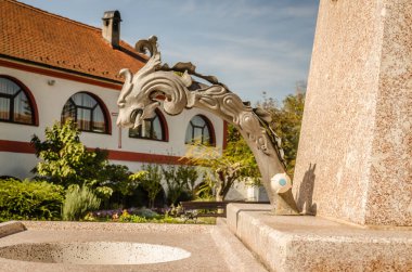 Kilise bahçesindeki çeşmenin manzarası. Sremska Kamenica 'daki Sırp Ortodoks Kilisesi - En Kutsal Meryem Ana' nın Doğumu Kilisesi.
