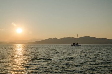 Evia Adası, Yunanistan - 01 Temmuz. 2020: Yunanistan 'ın Evia adasında günbatımı. Yunanistan 'ın Ege Denizi' ndeki Evia adasında günbatımının panoramik görüntüsü. Evia Yunanistan adasındaki sakin Ege Denizi 'nde güzel bir gün batımı