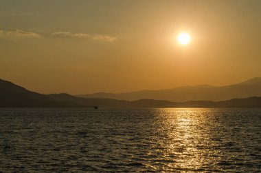 Evia Adası, Yunanistan - 01 Temmuz. 2020: Yunanistan 'ın Evia adasında günbatımı. Yunanistan 'ın Ege Denizi' ndeki Evia adasında günbatımının panoramik görüntüsü. Evia Yunanistan adasındaki sakin Ege Denizi 'nde güzel bir gün batımı
